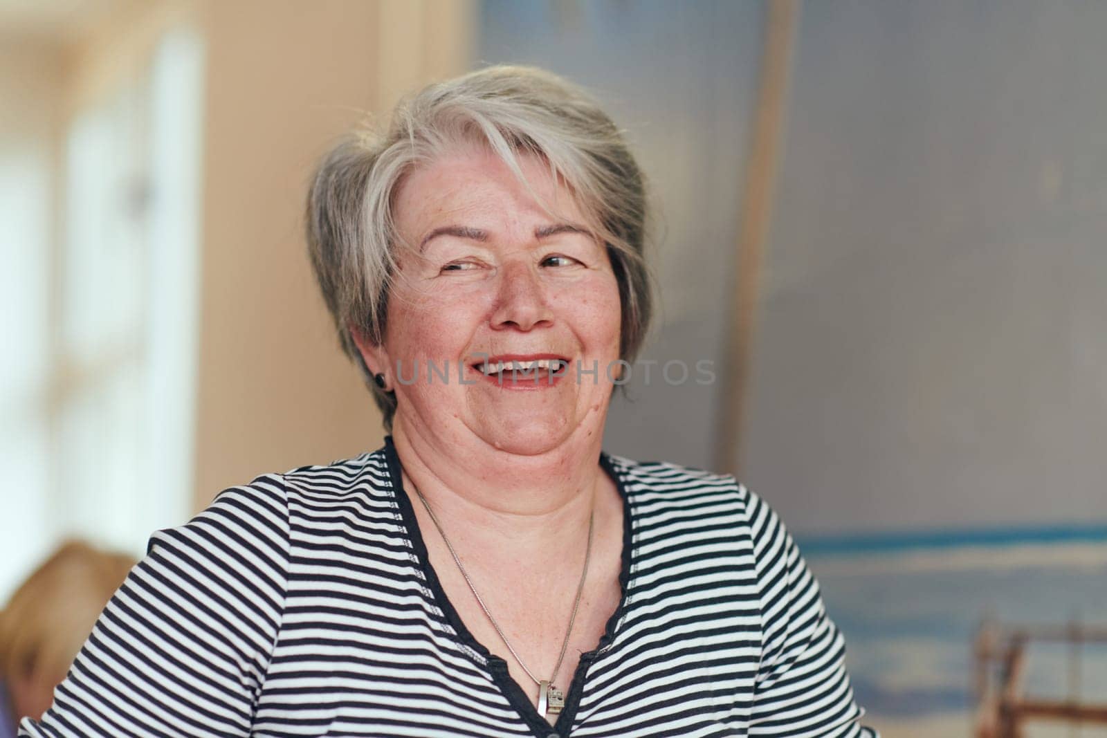 In a sunlit space, a senior woman gracefully practices rejuvenating yoga, focusing on neck, back, and leg stretches, embodying serenity and well-being by dotshock