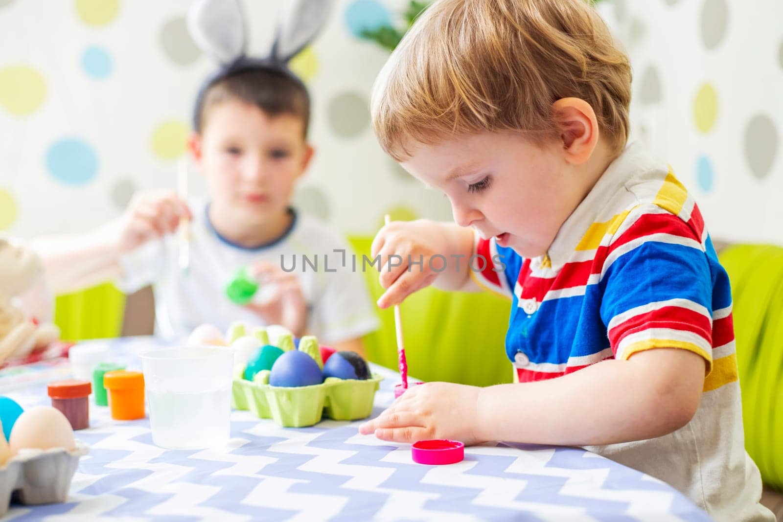 Happy Easter. Children dye colorful egg for Easter hunt by andreyz