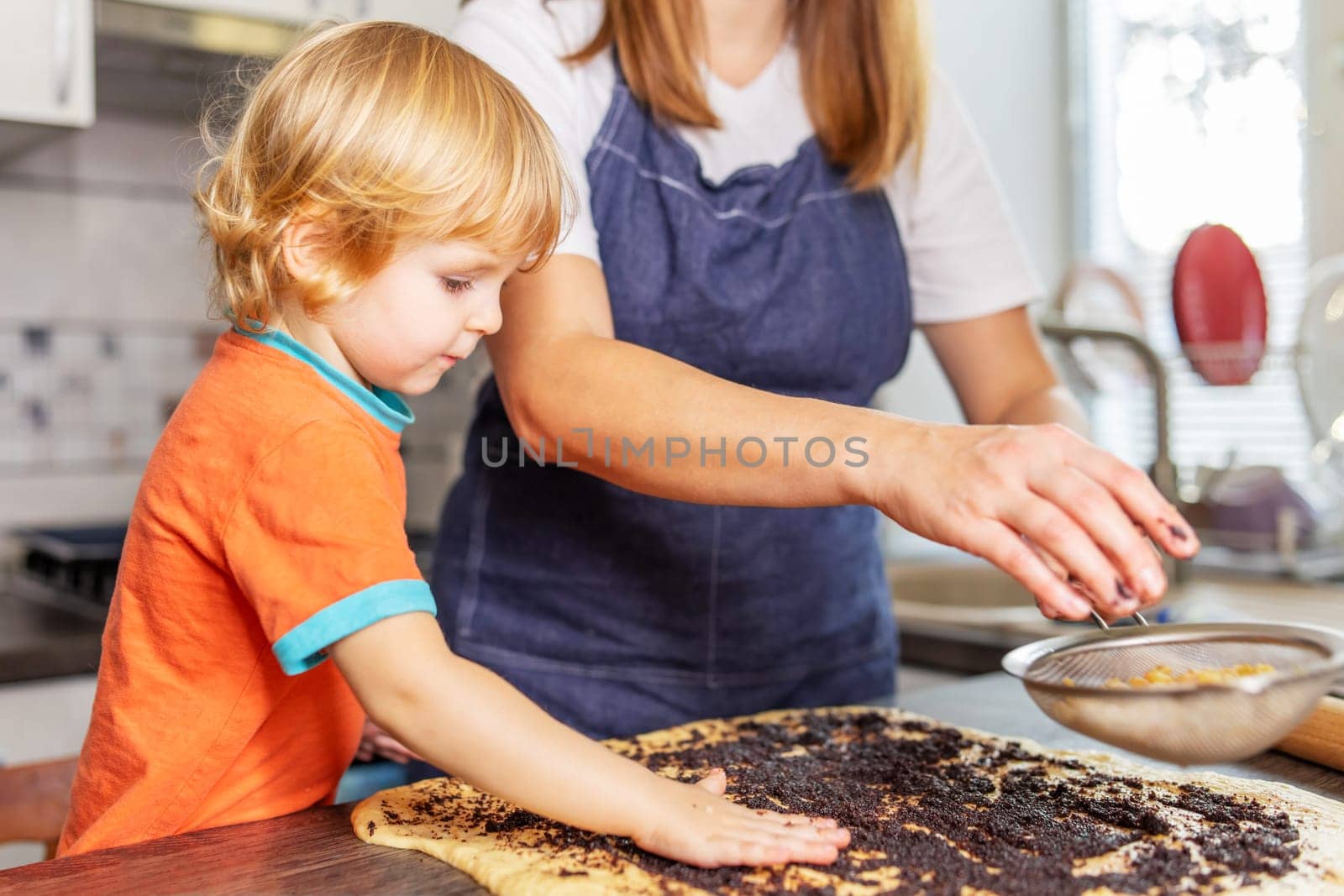 Happy loving family making bakery together. Mother and son boy making cookies and having fun in the kitchen. Homemade food and a little helper