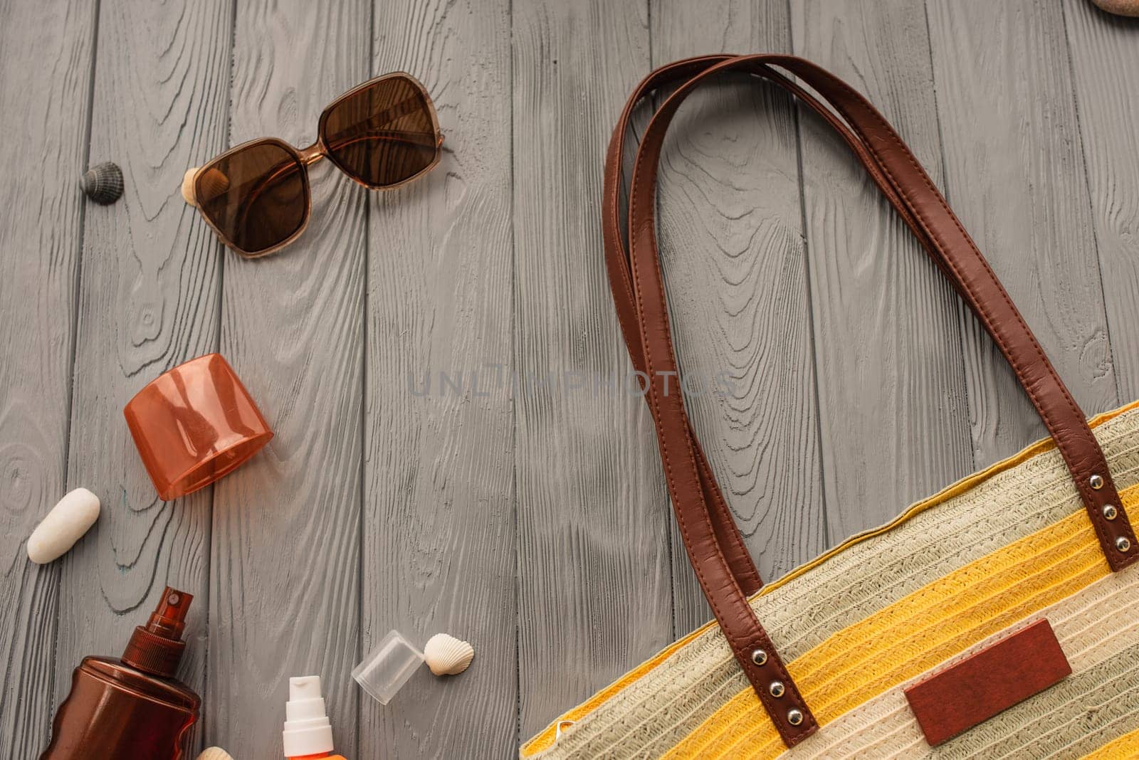 beachwear bag sun protection sunglasses sunscreen spray lotion cream care tan ultra-violet rays. Summer background template mockup free space pattern composition text. Top view above wooden background