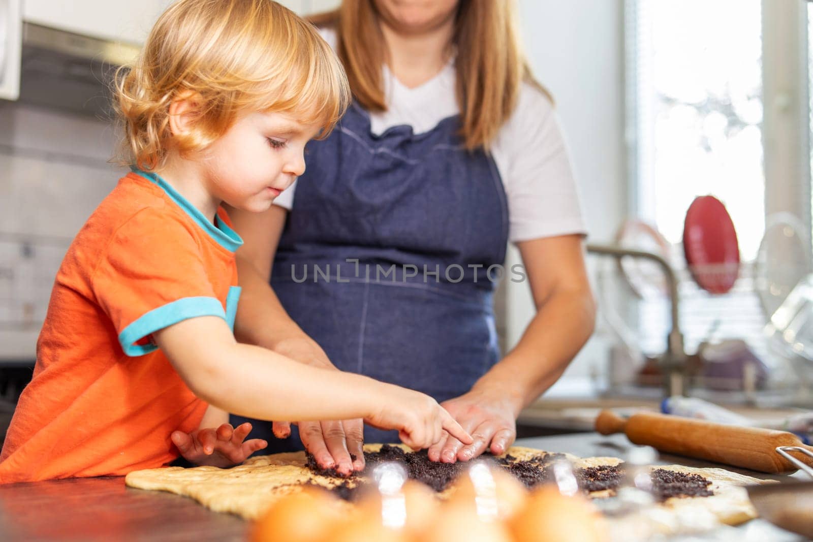 Mother and son boy making cookies and having fun in the kitchen by andreyz