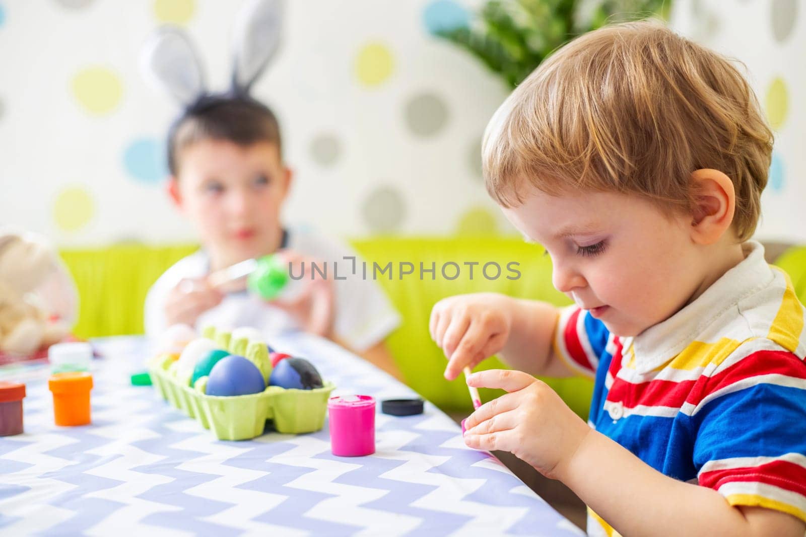 Happy Easter. Kids dyeing Easter eggs. Children dye colorful egg for Easter hunt. Happy family preparing for Easter