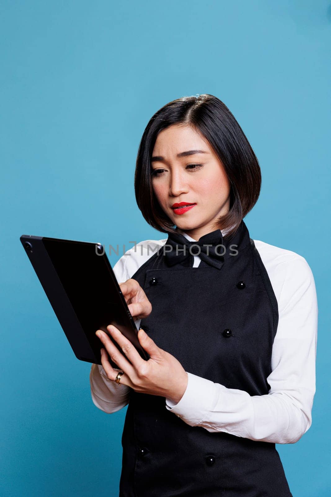 Restaurant employee tapping on tablet by DCStudio