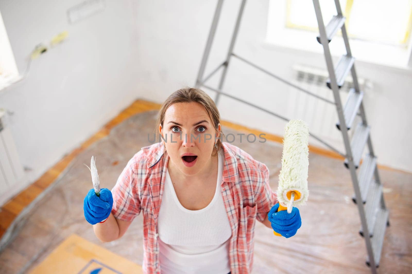 Tired, exhausted, stressed woman doing a home renovation. A woman faces many problems and difficulties in repairing