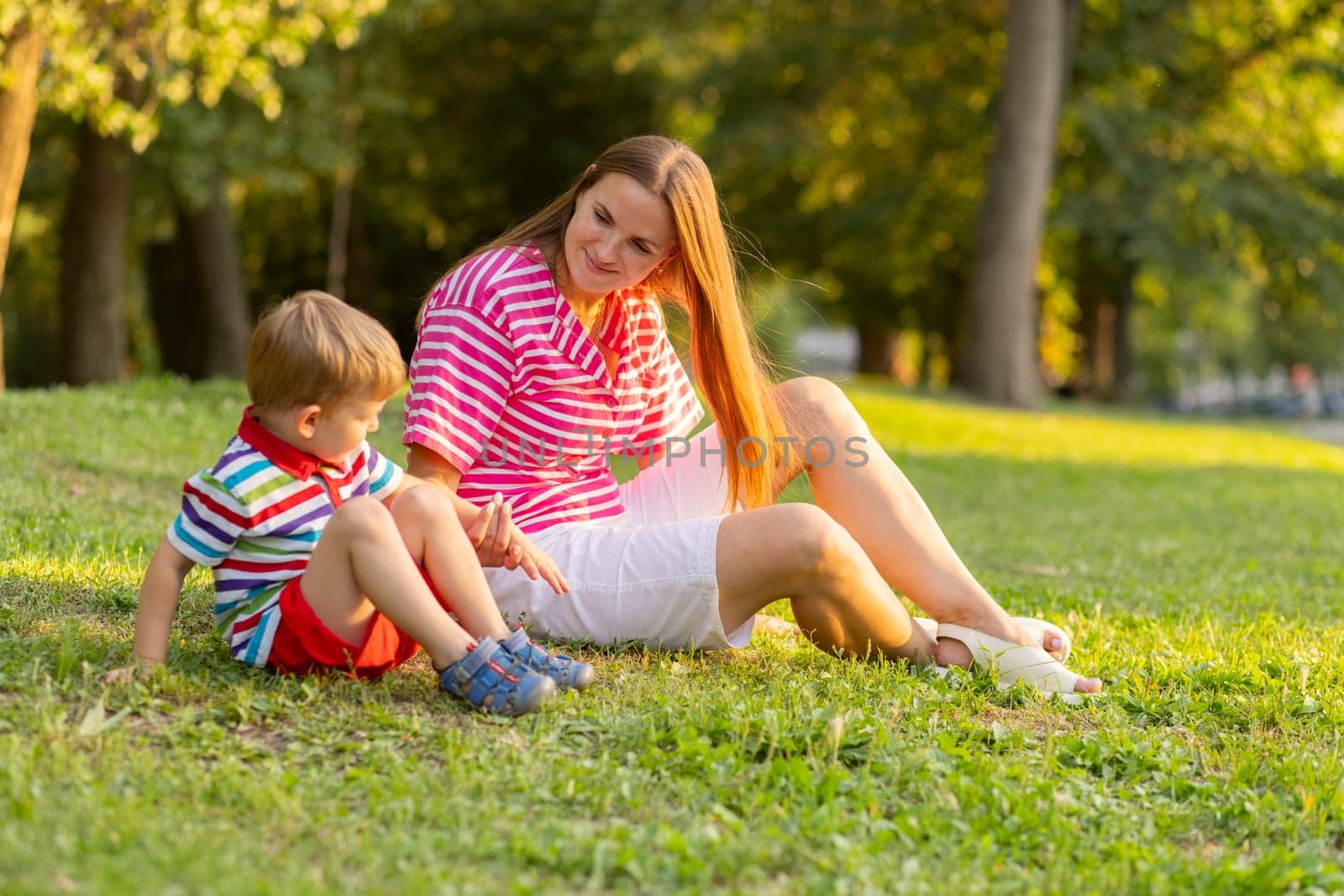 Mother having rest with her little kid son together outdoors in park by andreyz