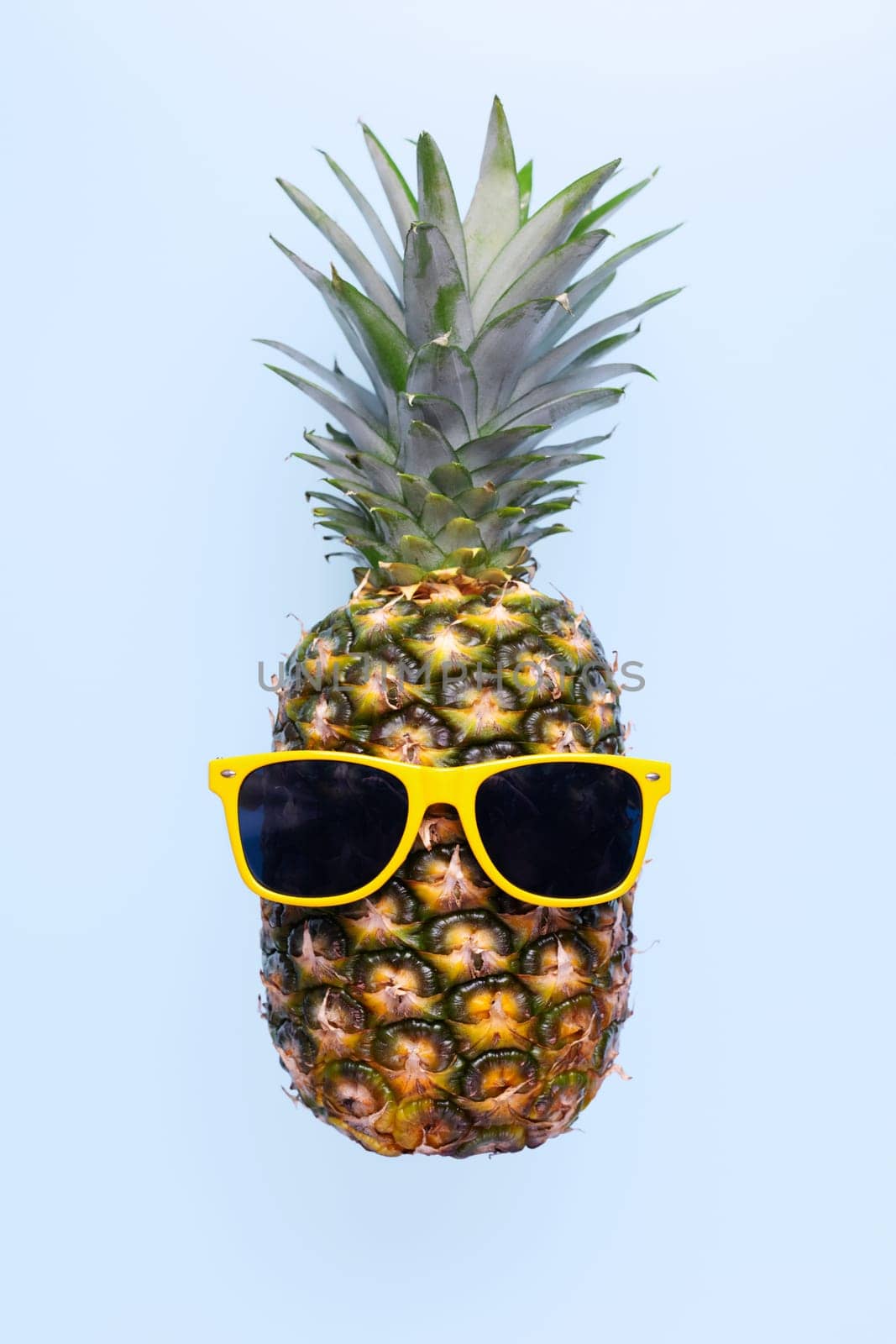 Pineapple with sunglasses on blue background by andreyz