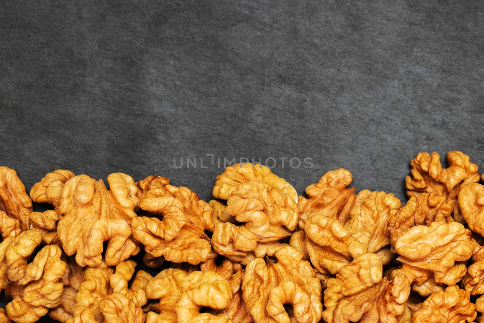 Walnuts. Walnut kernels on dark stone table. Top view.