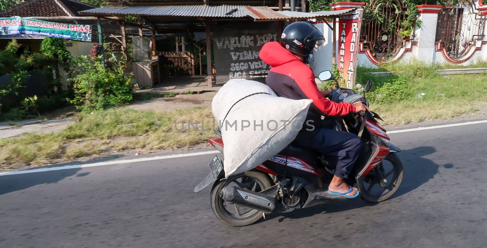 motorbike riding in asia as one of goods transportation method, being used to transport many kind of goods intercity in central java indonesia