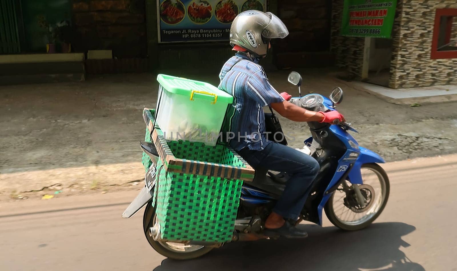 motorbike riding in asia as one of goods transportation method, being used to transport many kind of goods intercity in central java indonesia