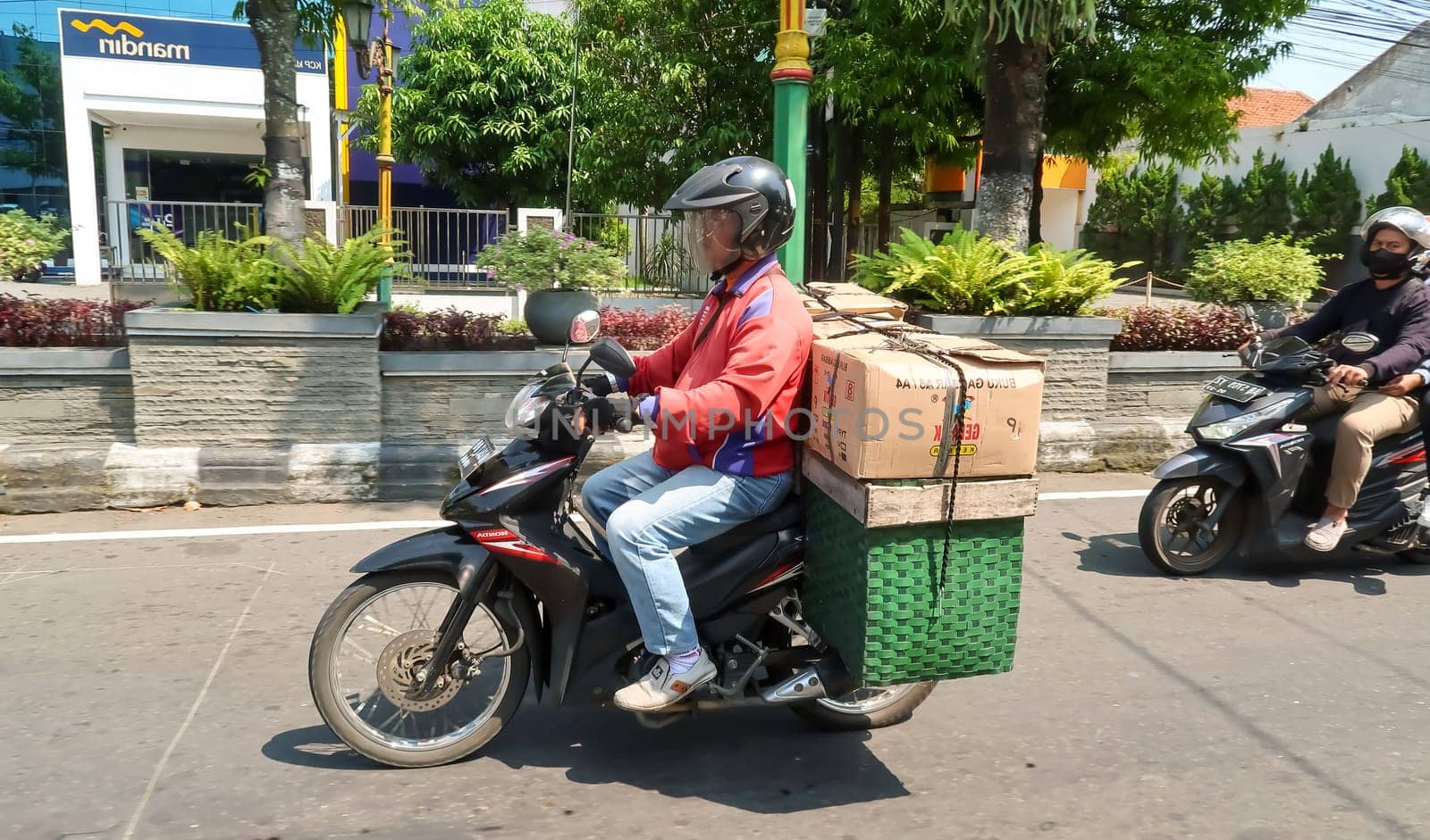 motorbike riding in asia as one of goods transportation method, being used to transport many kind of goods intercity in central java indonesia