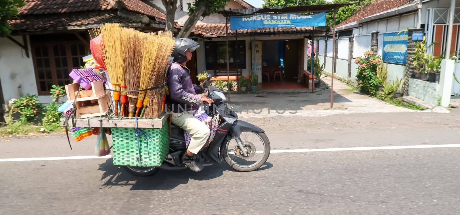 motorbike riding in asia as one of goods transportation method, being used to transport many kind of goods intercity in central java indonesia