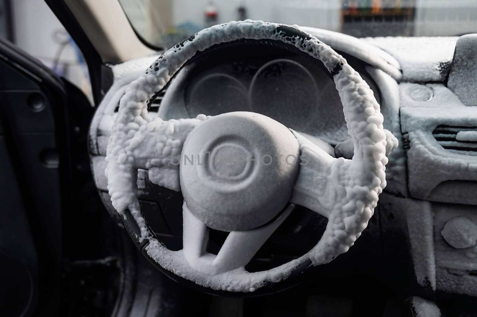 Car interior in a layer of cleaning foam