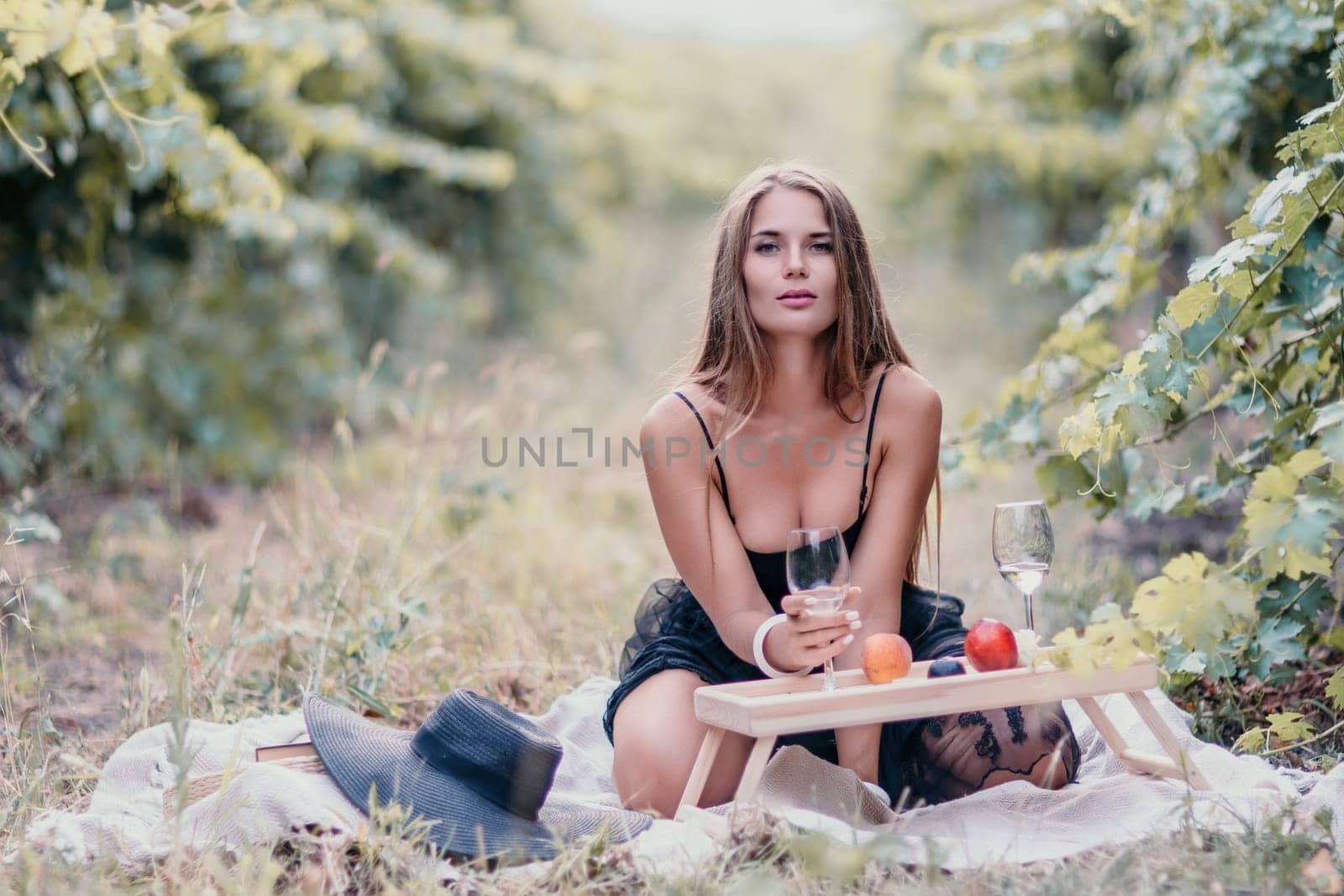 Picnic and wine tasting at sunset in the hills of Italy, Tuscany. Vineyards and open nature in the summer. Romantic dinner, fruit and wine.