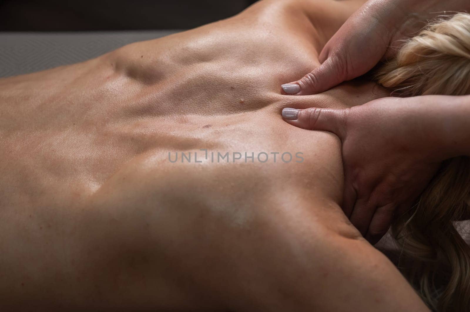 A woman undergoing a massage of the cervical-collar area. by mrwed54