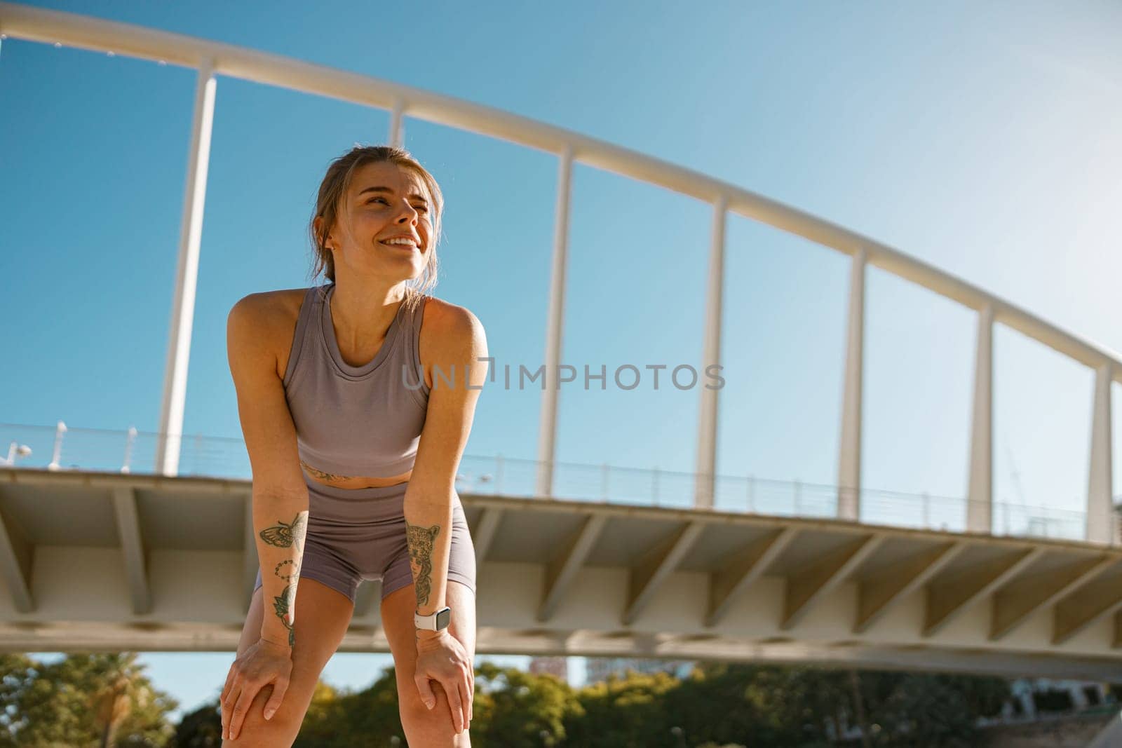 Female athlete in sportswear have a rest after morning jogging outside and looks away by Yaroslav_astakhov