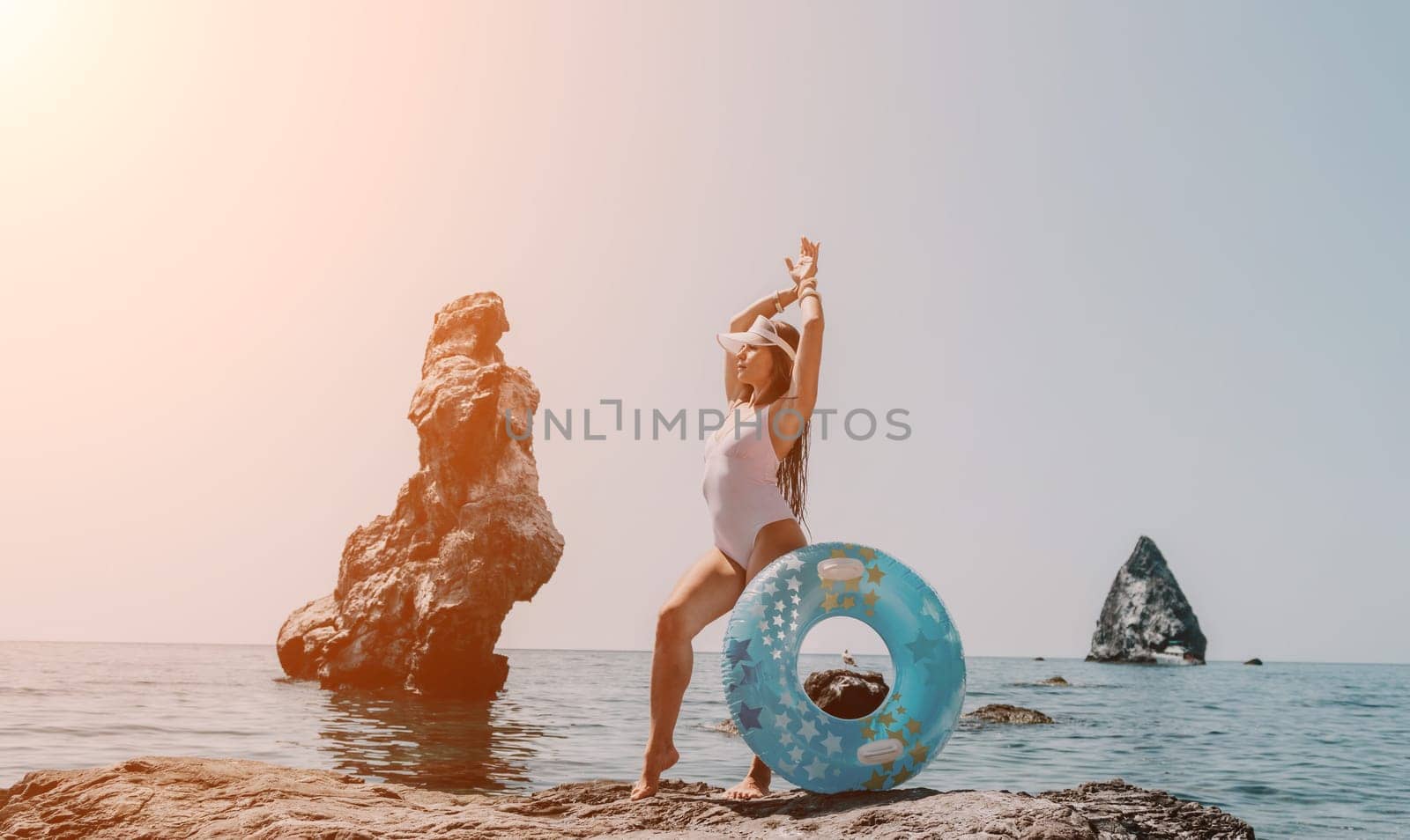 Woman summer sea. Happy woman swimming with inflatable donut on the beach in summer sunny day, surrounded by volcanic mountains. Summer vacation concept. by panophotograph