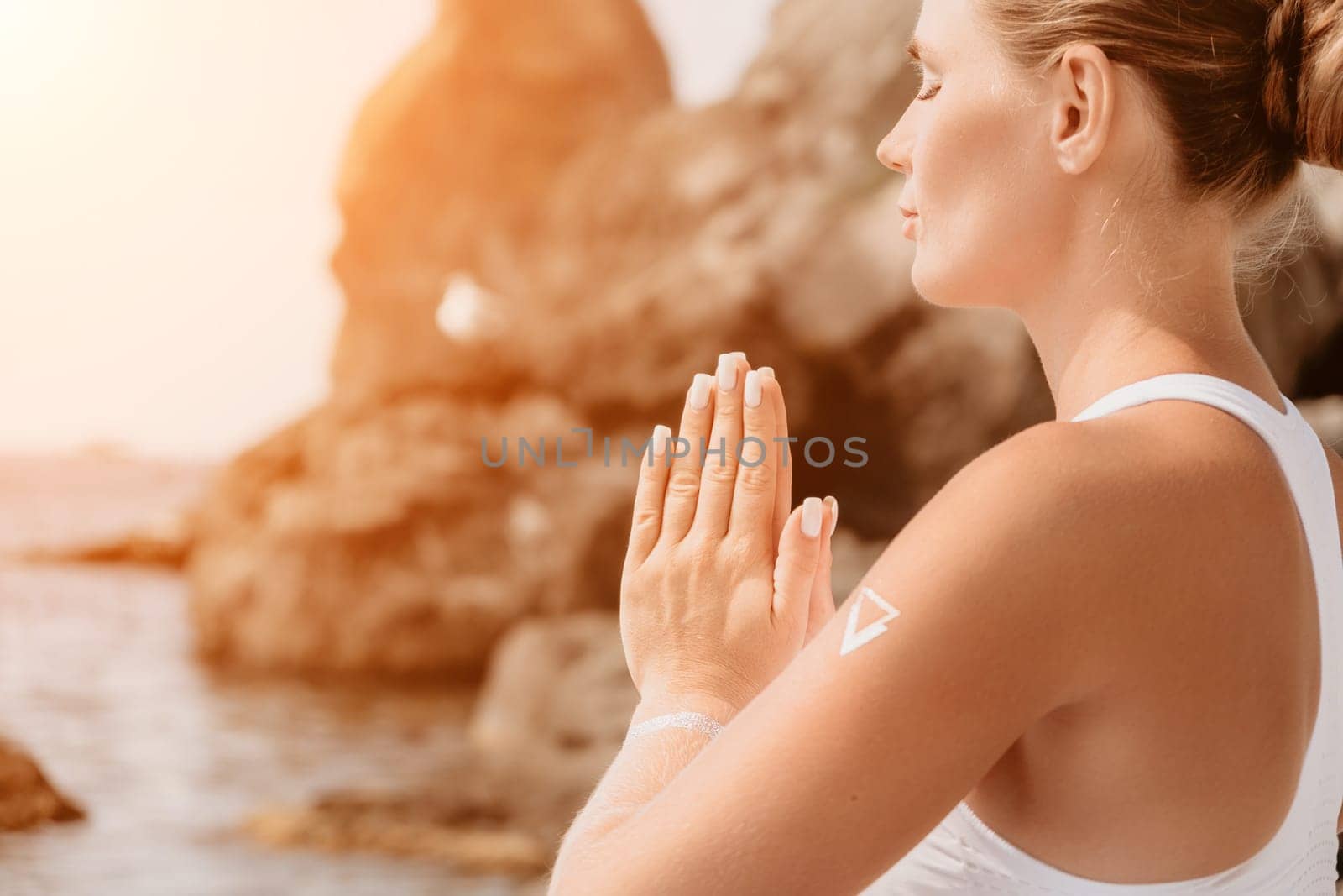 Woman sea yoga. Back view of free calm happy satisfied woman with long hair standing on top rock with yoga position against of sky by the sea. Healthy lifestyle outdoors in nature, fitness concept.