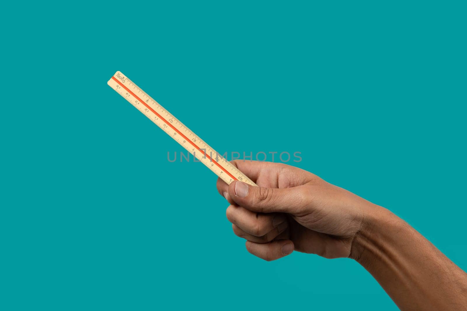 Black male hand holding a vintage ruler isolated on turquoise background. by TropicalNinjaStudio
