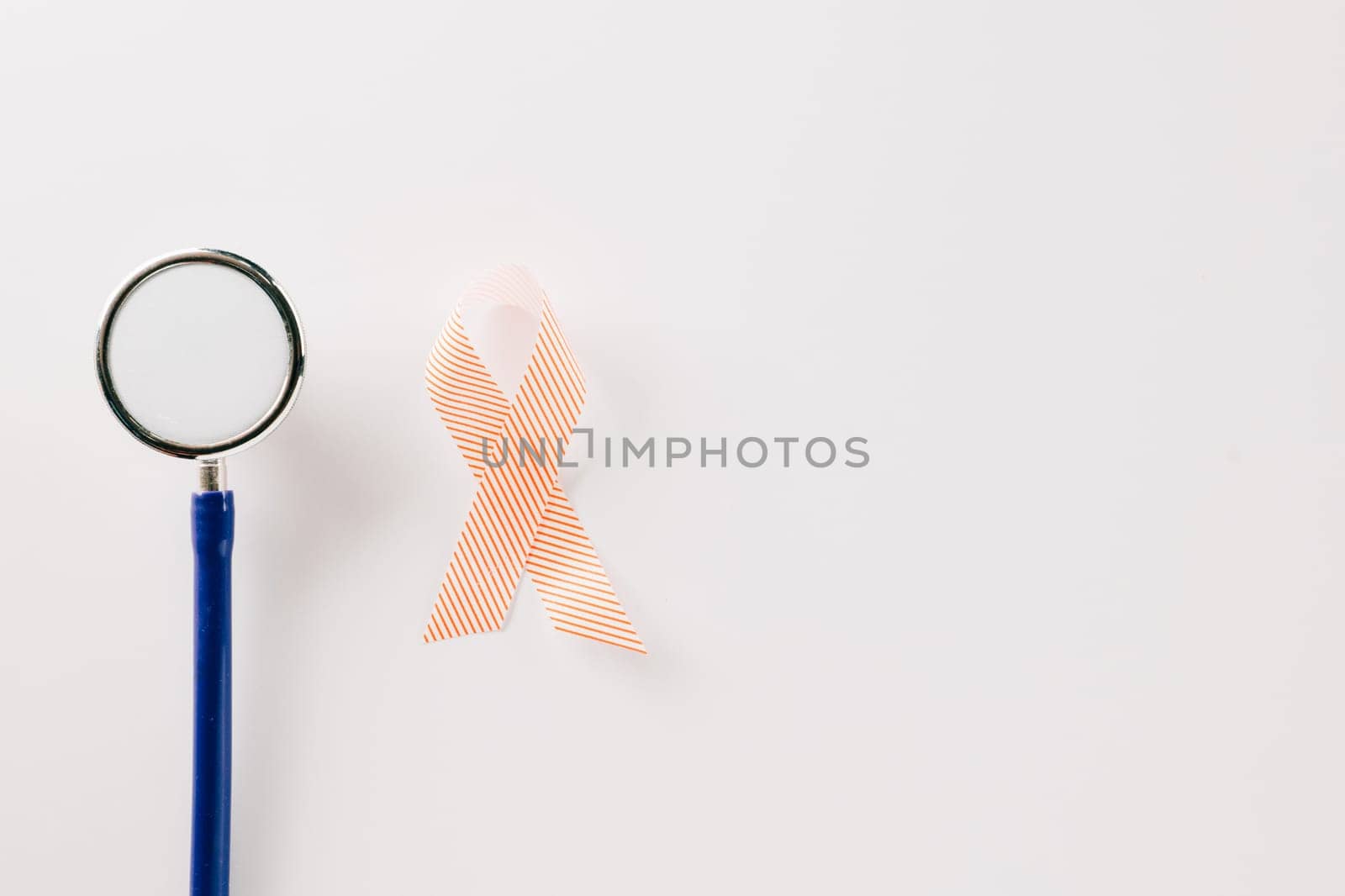Pink awareness ribbon sign and stethoscope of International World Cancer Day campaign month isolated on white background with copy space, concept of medical and health care support, 4 February