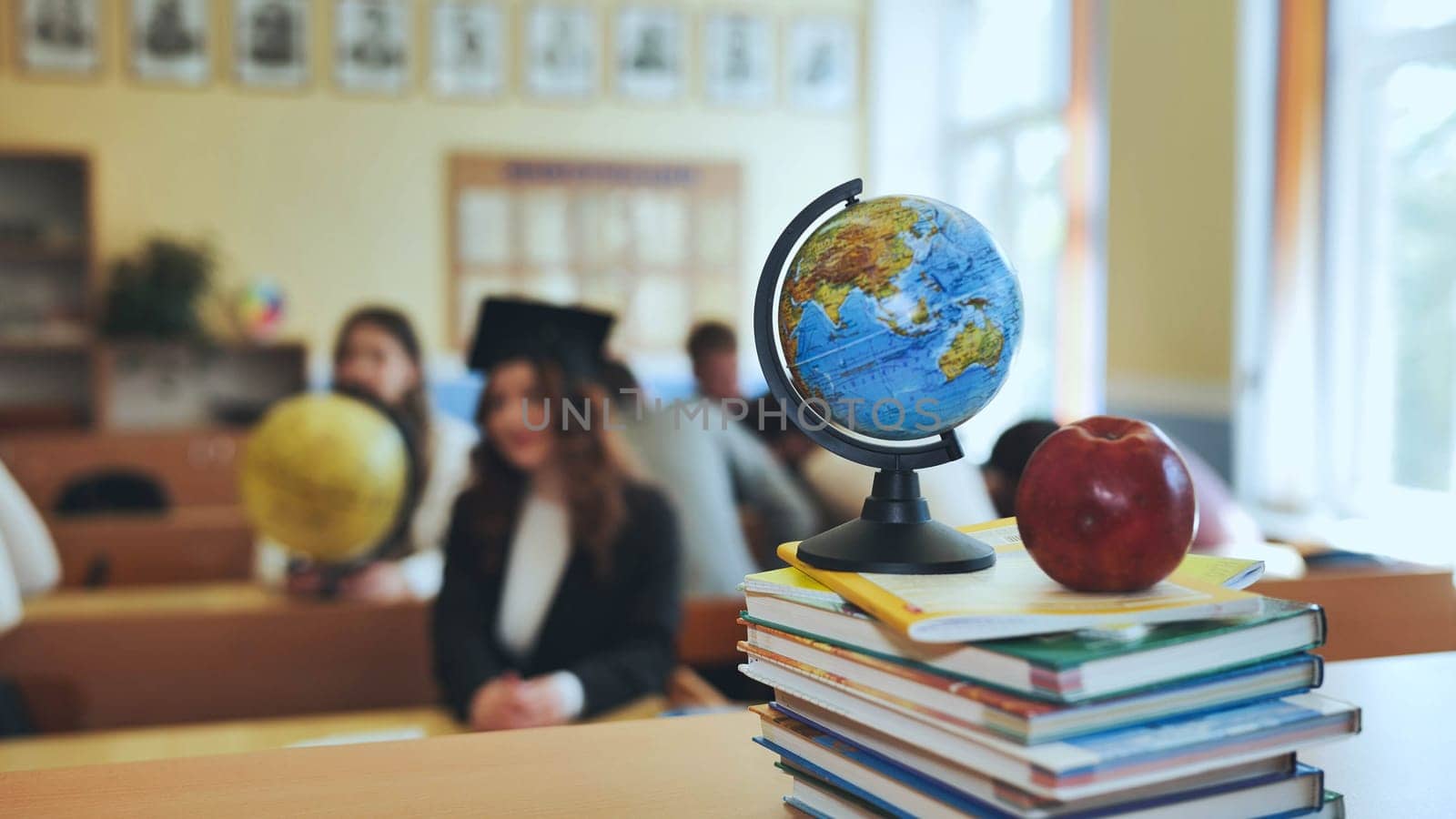 Globe of the world with textbooks and an apple in the background of a lesson in a school classroom