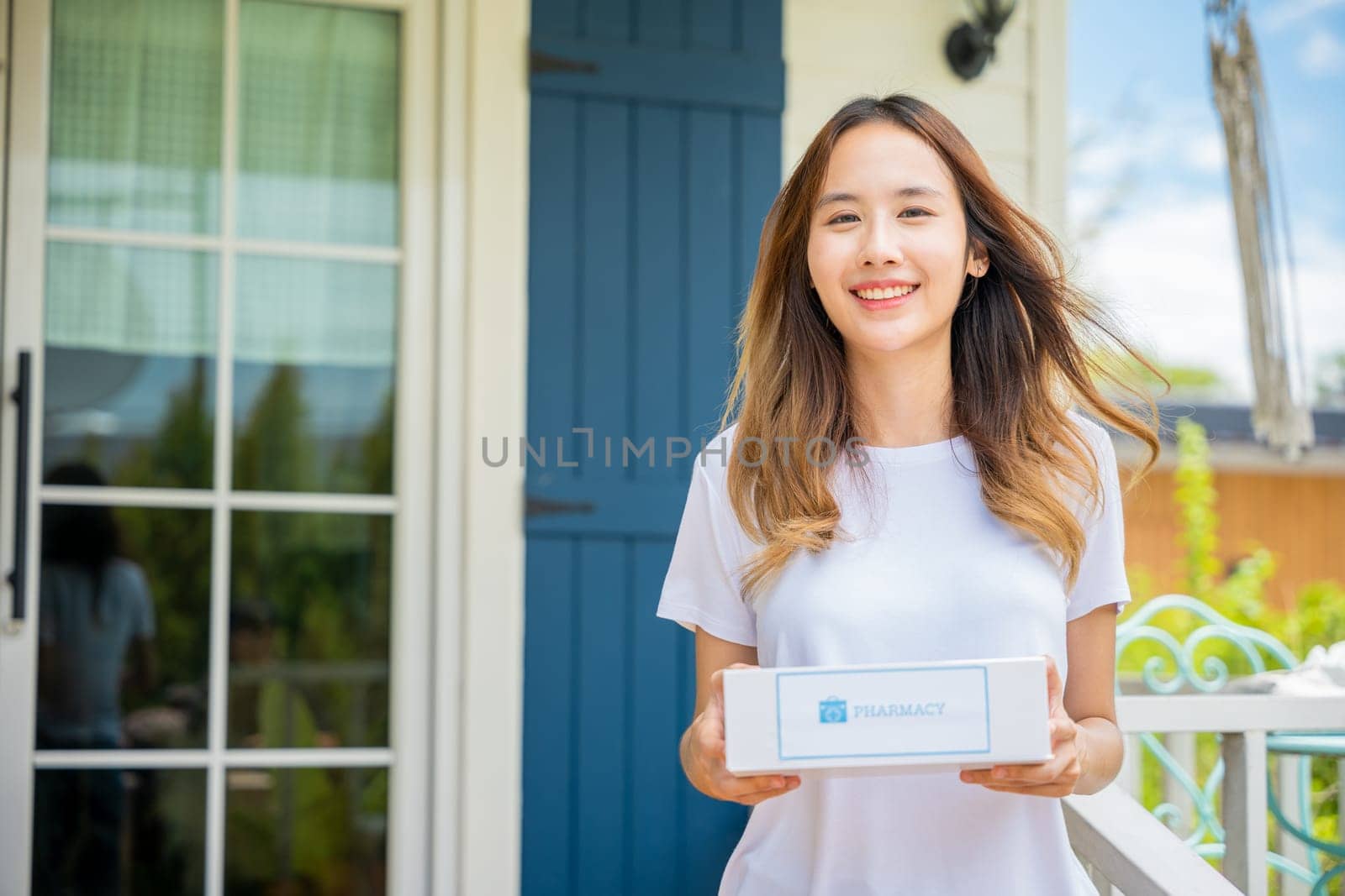 Online delivery medical. Portrait of Asian young woman smile hold medication box first aid shipment received from pharmacy hospital delivery at home patient, Buy online clinic retail Rx drug store