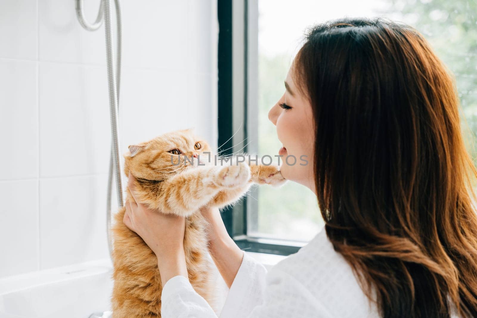 A clean and joyful bathroom scene, An adult woman lovingly holds her Scottish Fold cat during her bath, radiating pure owner-pet love. by Sorapop