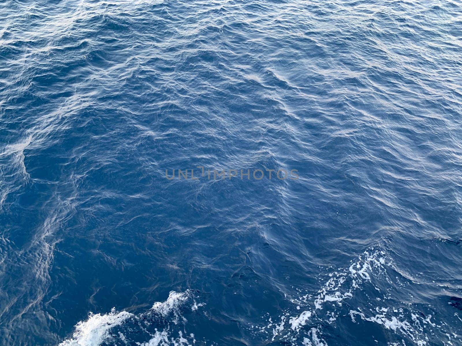 Photo of abstract blue color water wave, pure natural swirl pattern texture, background photography, Blue ocean water texture background. Surface of the sea in bali indonesia