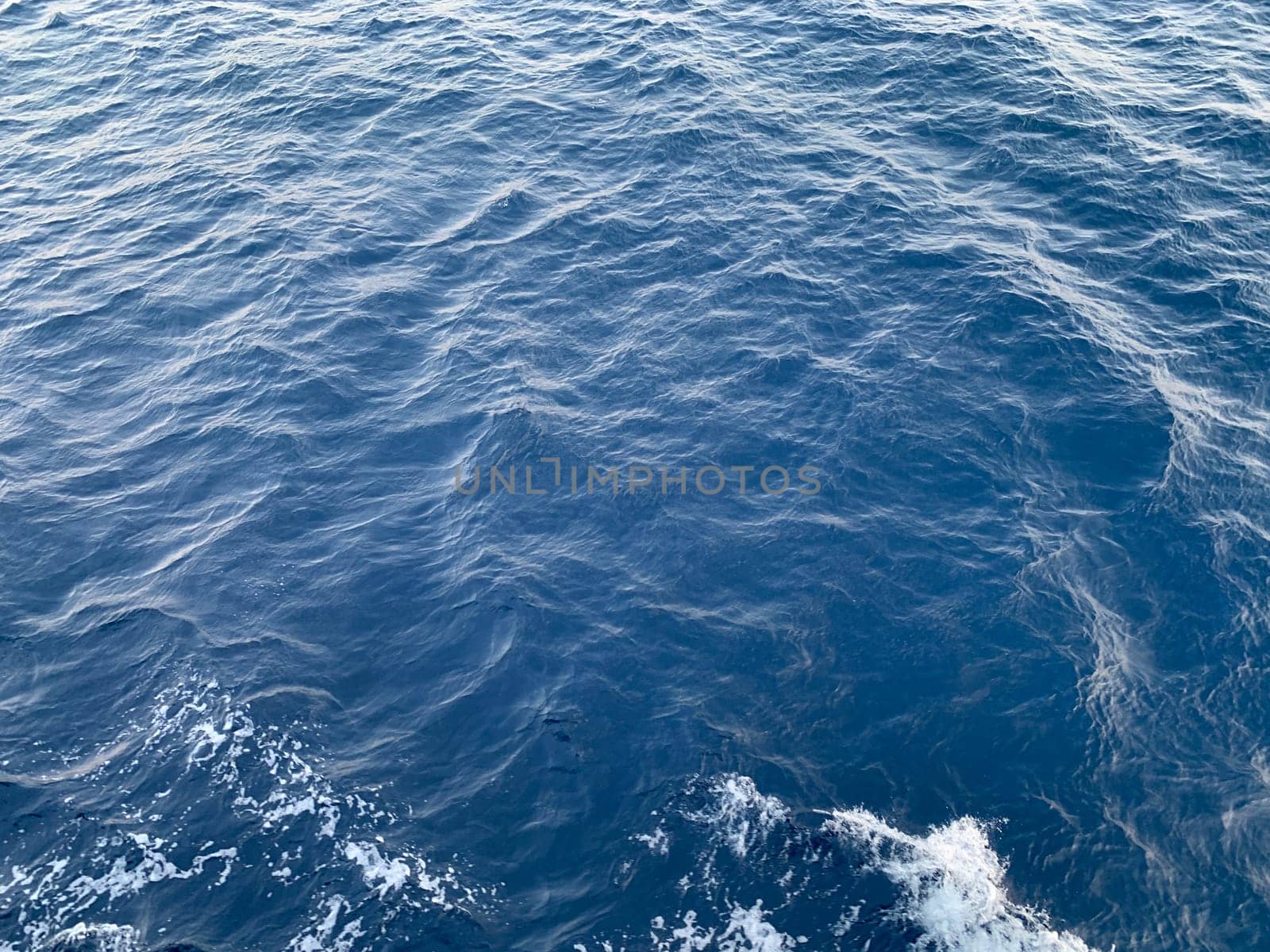 Photo of abstract blue color water wave, pure natural swirl pattern texture, background photography, Blue ocean water texture background. Surface of the sea in bali indonesia