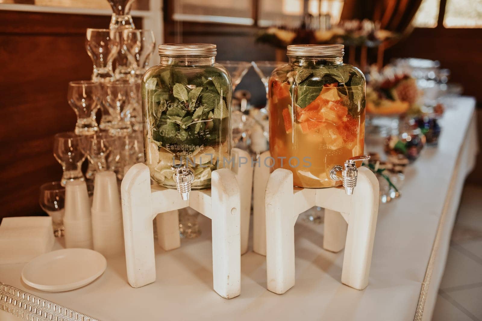 Catering. Drinks on wedding party. Cocktail glasses full of red alcohol stand on table. Beautiful row line of different colored alcohol cocktails with mint on a open air party, martini, vodka fresh