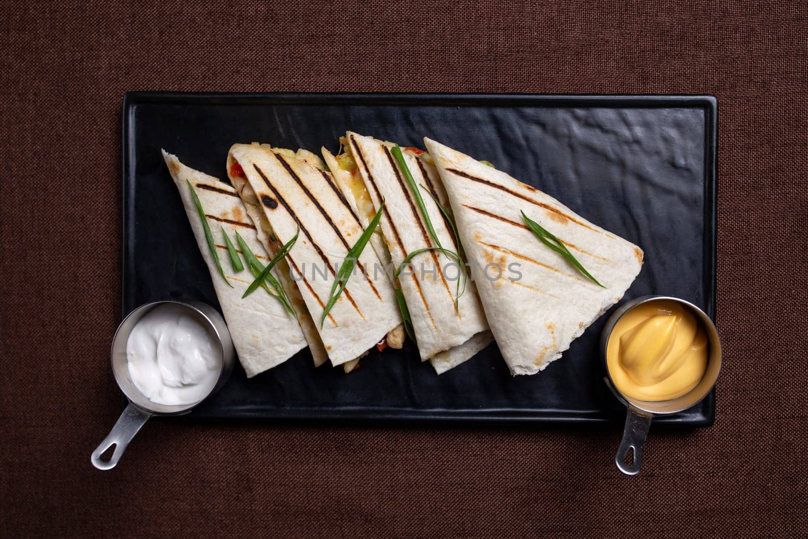 top view of quesadilla with grilled chicken and cheese with vegetables, sour cream, salsa by Pukhovskiy