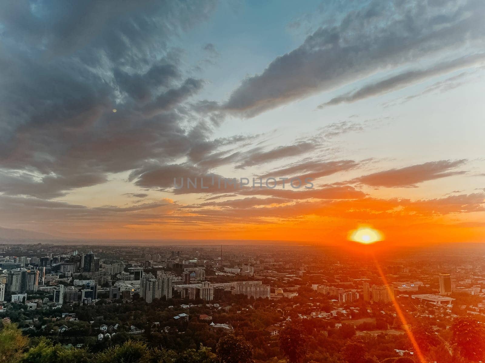 Vibrant Cityscape at Sunset with Colorful Sky and Clouds by Pukhovskiy