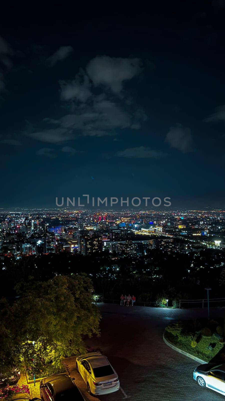 High angle view of city lights at night, urban landscape with bright lights from above, big city scene with stars in the sky.