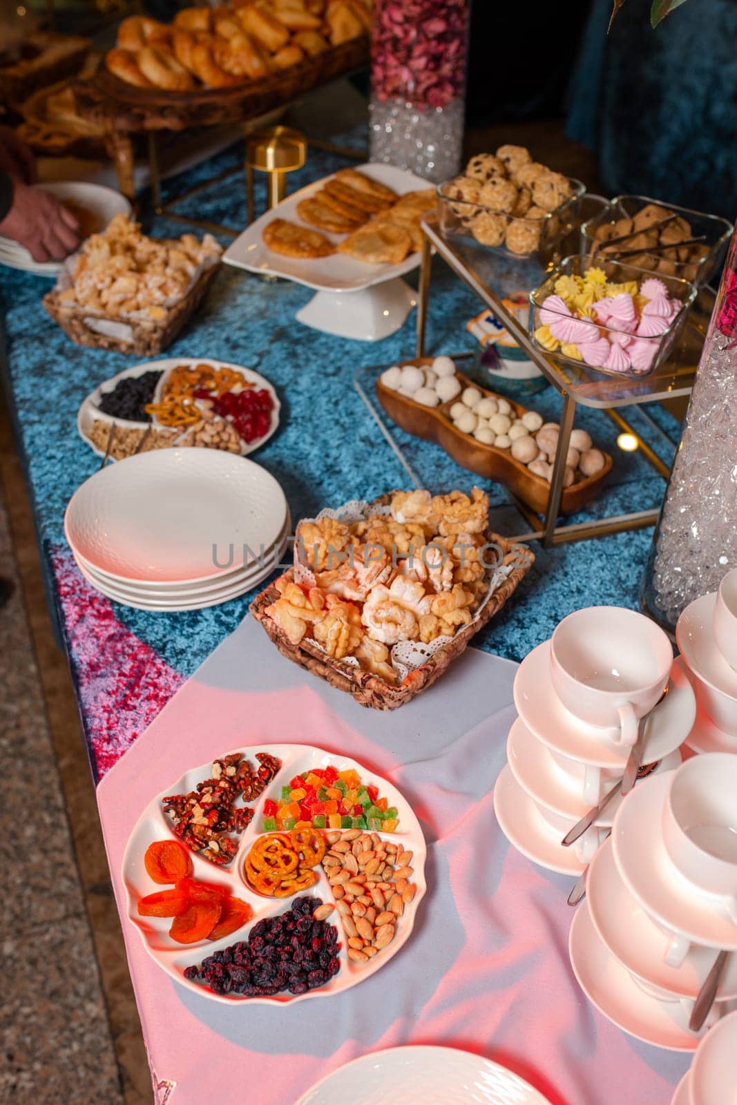 top view of Kazakhstani treats. An assortment of pastries, cookies, and nuts arranged on a blue velvet tablecloth. Perfect for a party or special occasion.