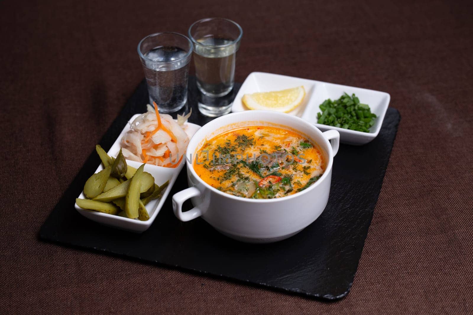 Traditional pickle, lightly salted cucumbers, cabbage and lemon with two glasses of alcohol by Pukhovskiy