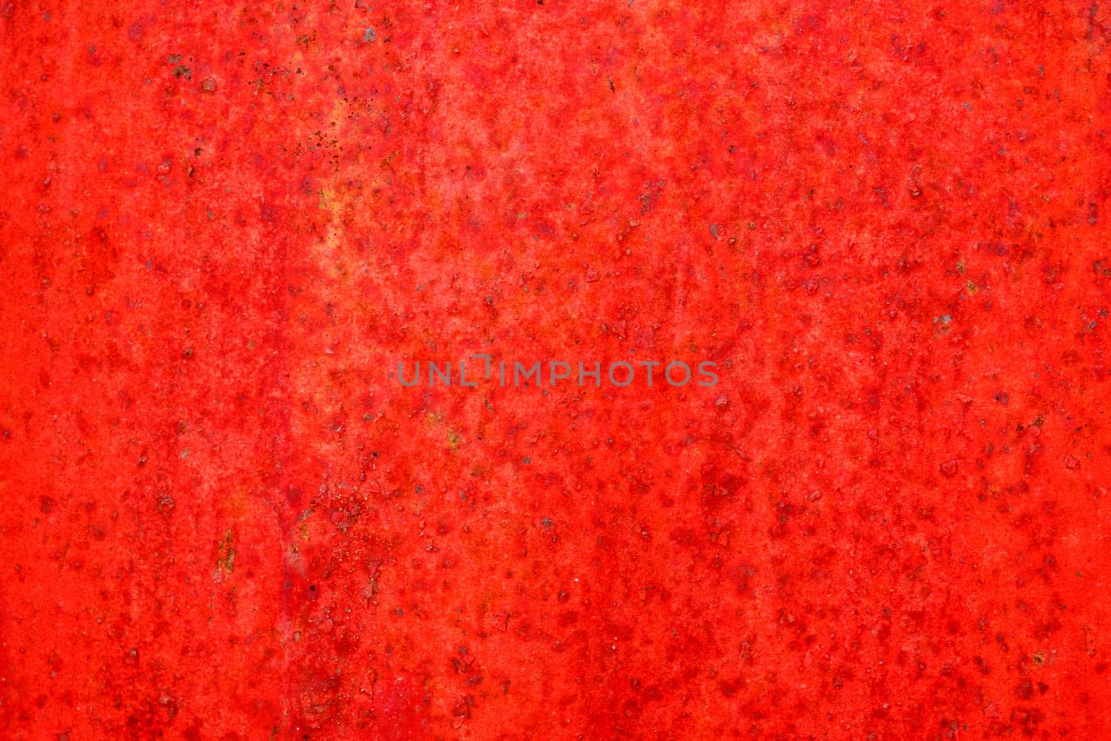 Red metal and paint creating textured wall background