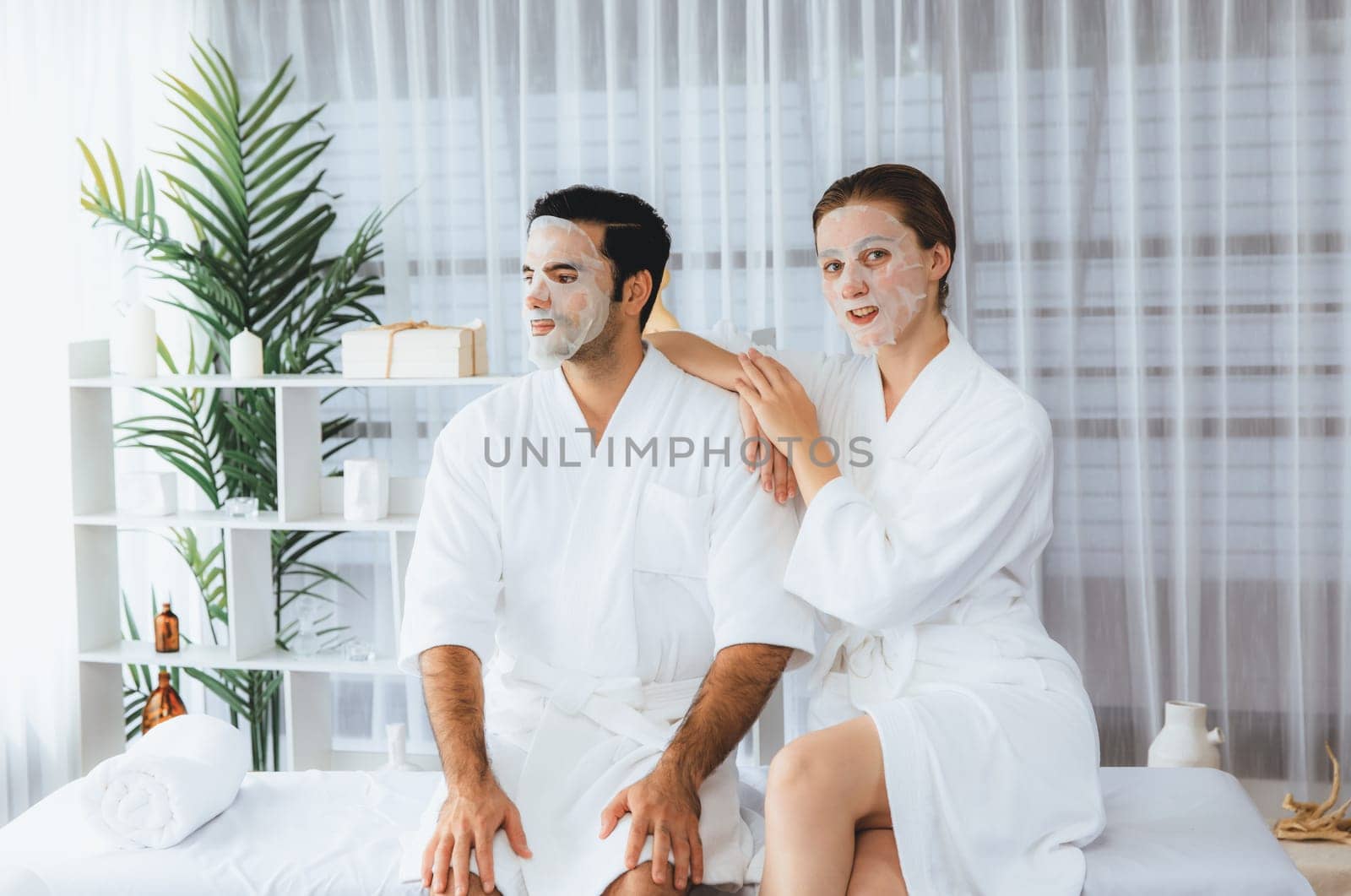 Serene modern daylight ambiance of spa salon, couple customer indulges in rejuvenating with facial skincare mask. Facial skin treatment and beauty cosmetology procedure for face. Quiescent