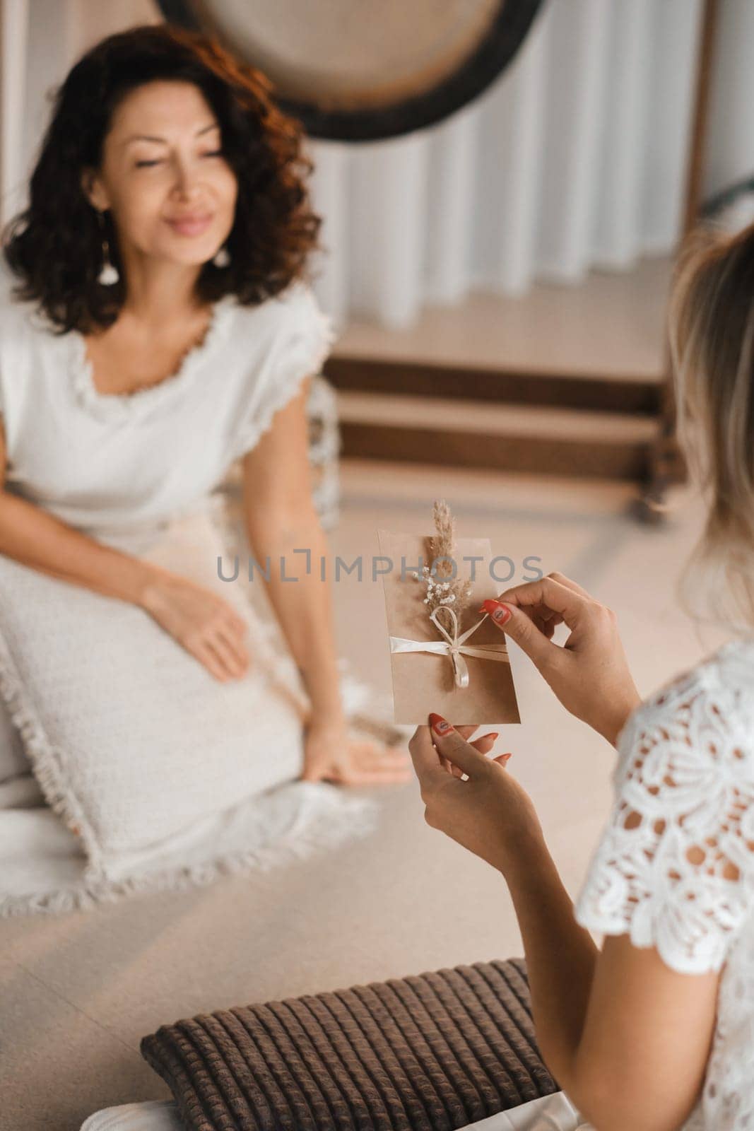 A woman in white clothes holds an envelope with a wish in her hands. The concept of a women's circle.