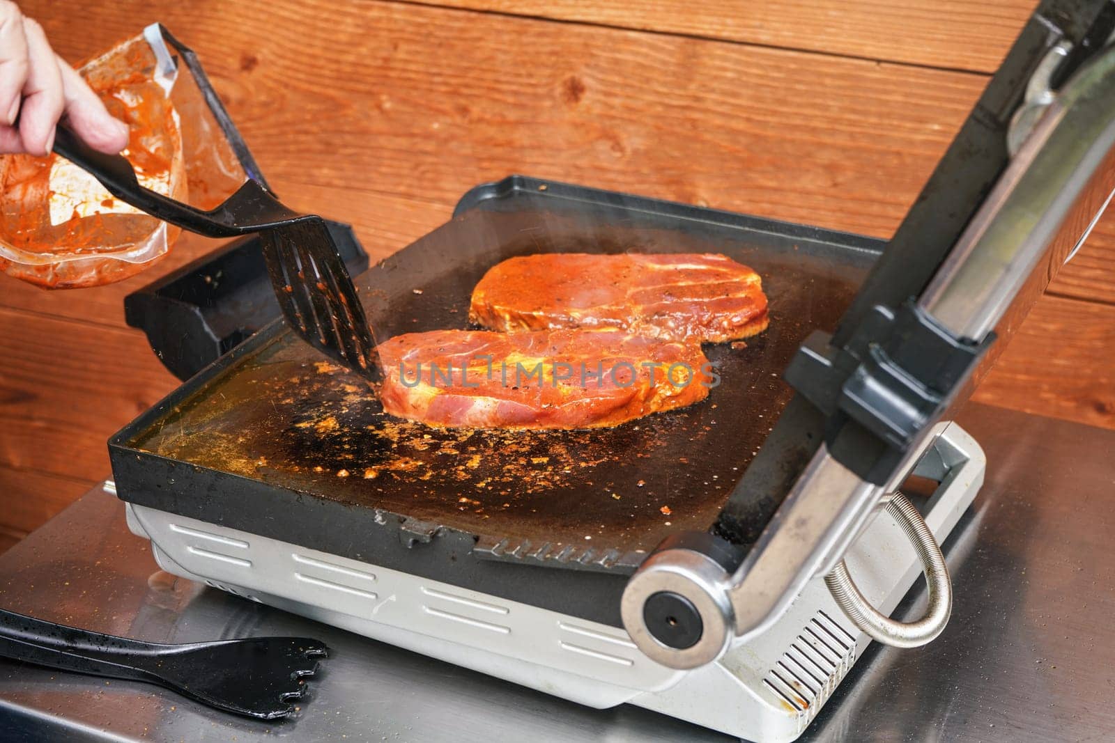 Two pork steak cutlets grilled on electric grill