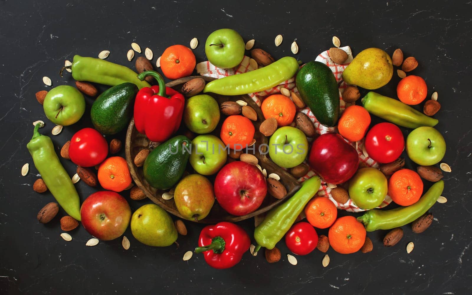 Mixed fruit and vegetables with some nuts on black board, view from above by Ivanko