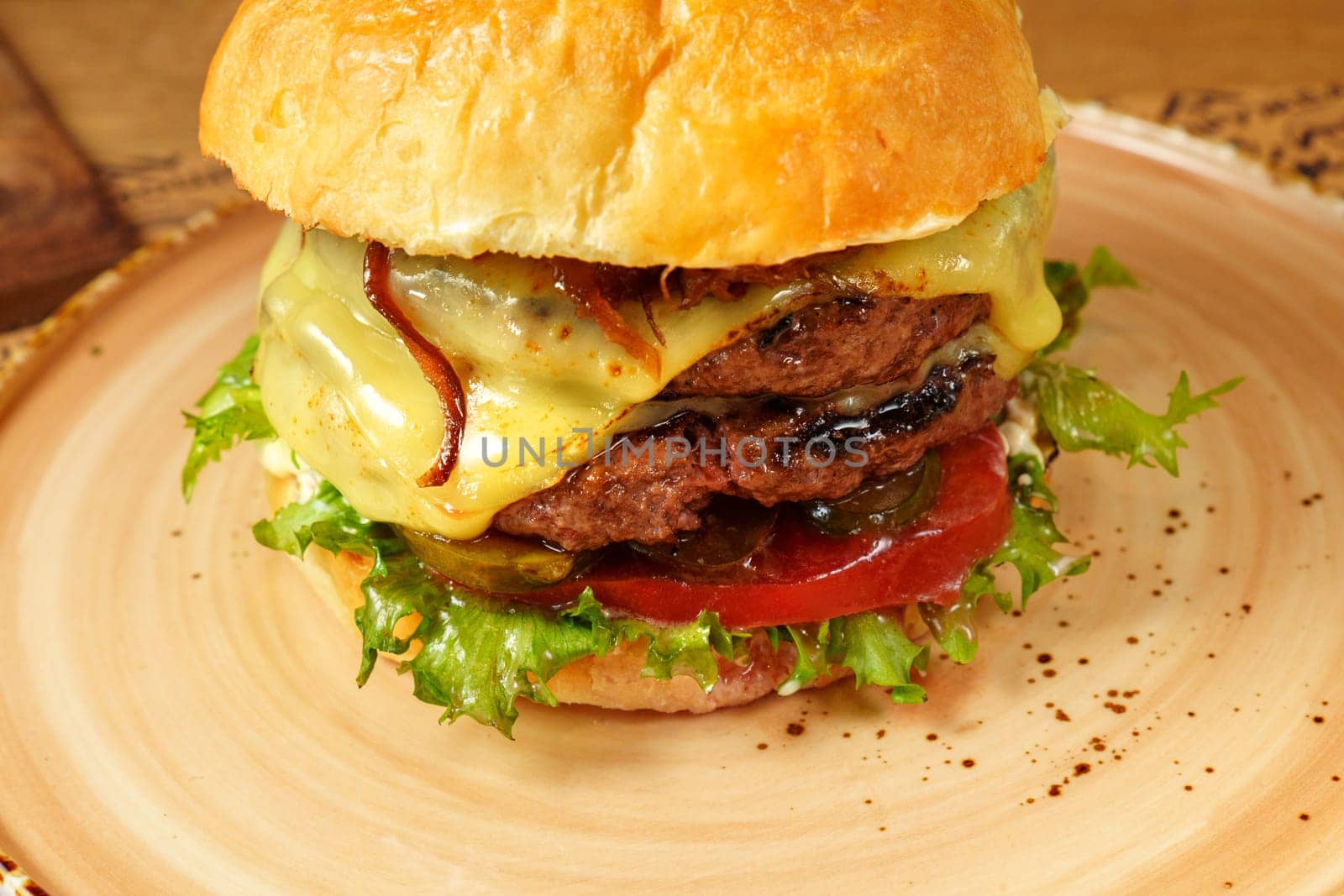 Cheeseburger topped with fresh lettuce and tomato on a sesame seed bun, ready to be enjoyed. by darksoul72