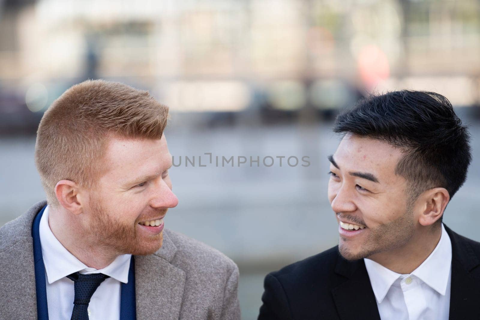 Close up portrait of two corporate executives smiling and discussing together outdoors.