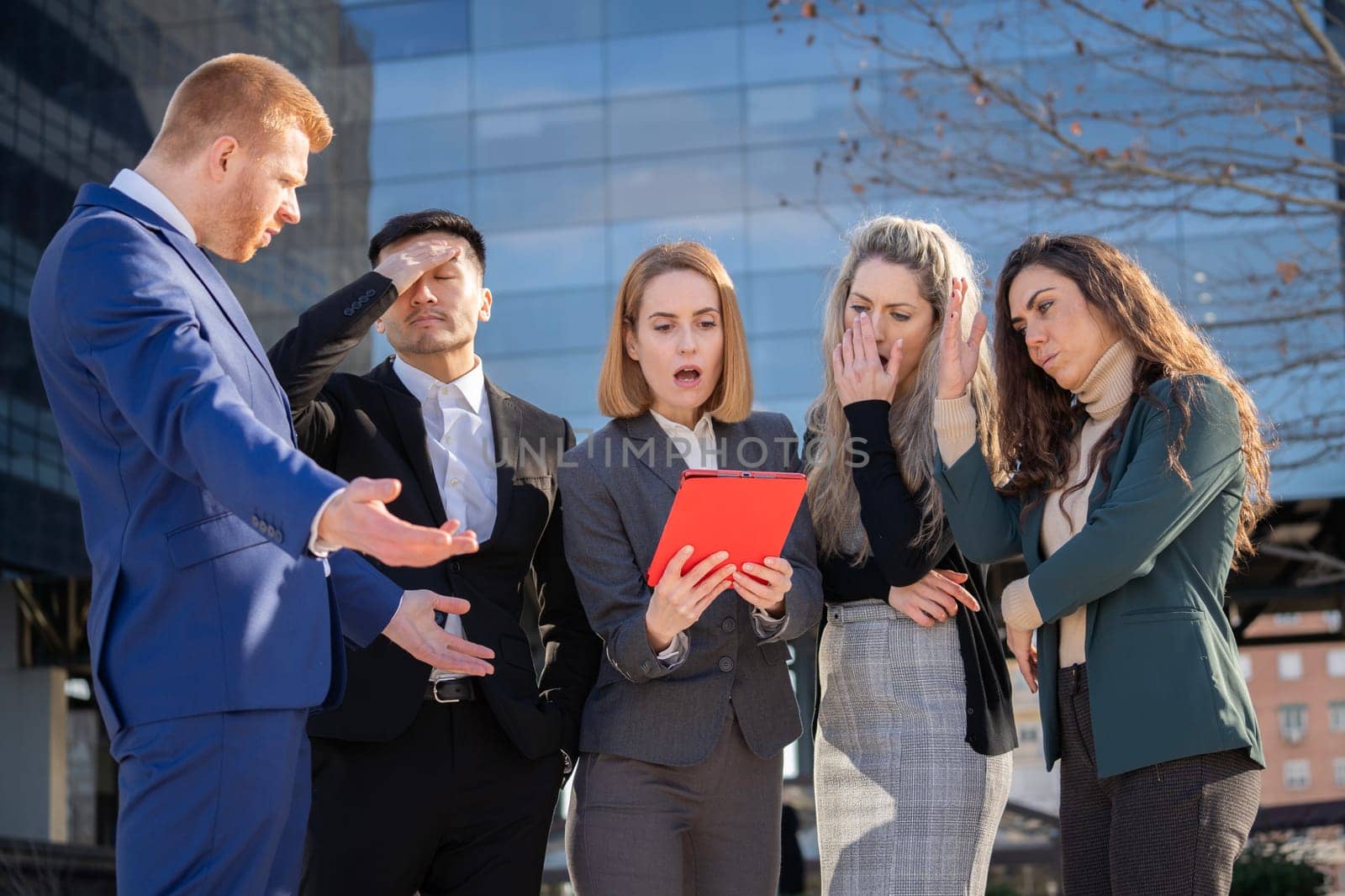 Upset corporate executives with negative expressions after bad news outside their office.