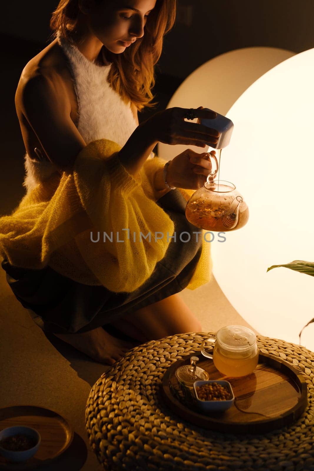 A young girl conducts an evening tea drinking procedure indoors. Relaxing tea party.