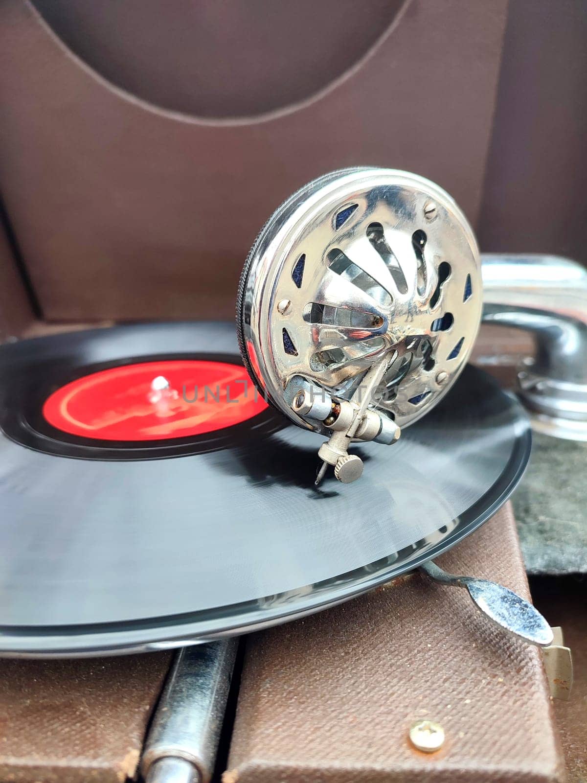 An old retro record playing on old vintage gramophone at flea market. Work of portable gramophone. Old vintage shabby record player, phonograph, potefone. Needle close up. Nostalgia antique turntable