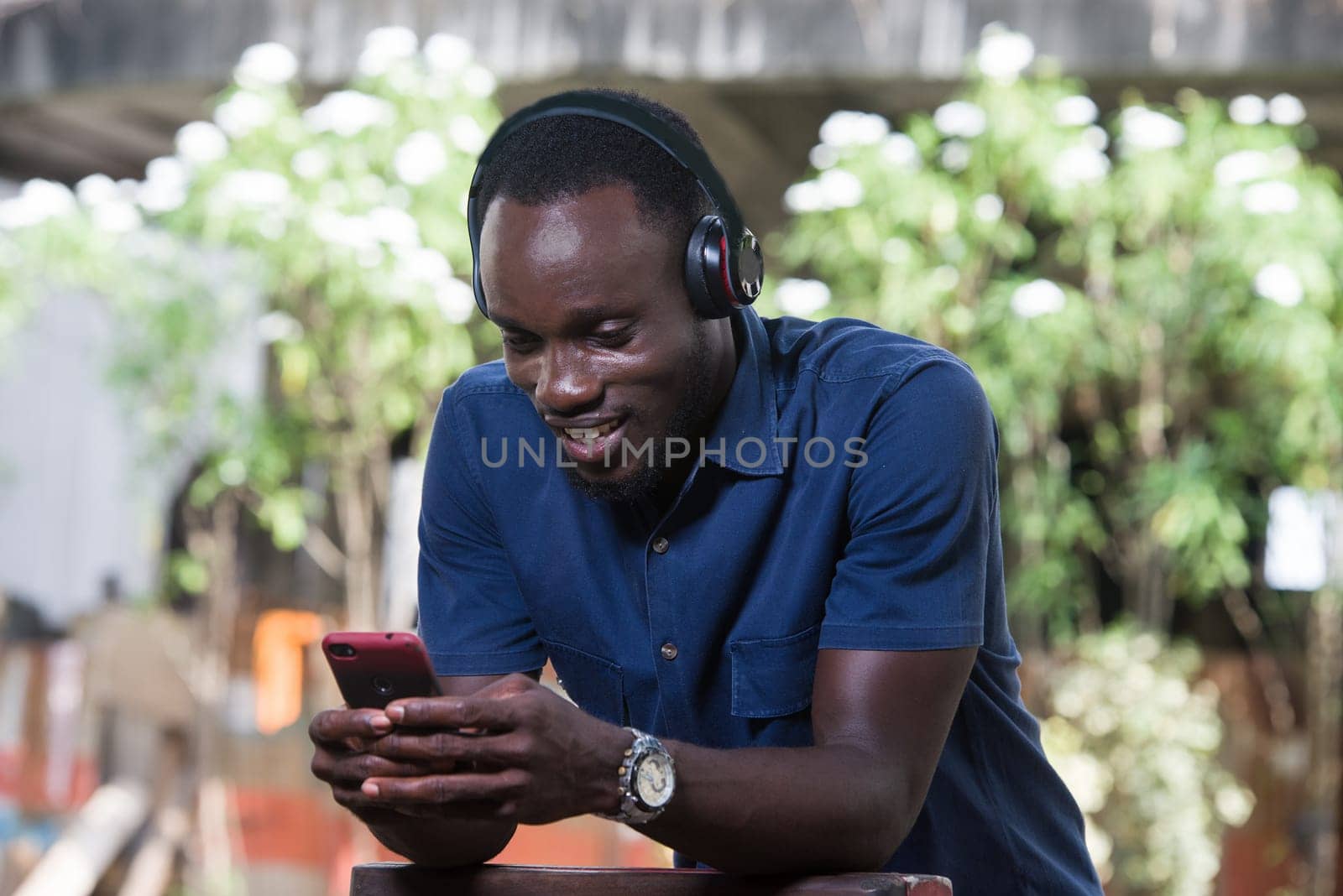 Mature man with headphones listening to music outdoors. by vystek