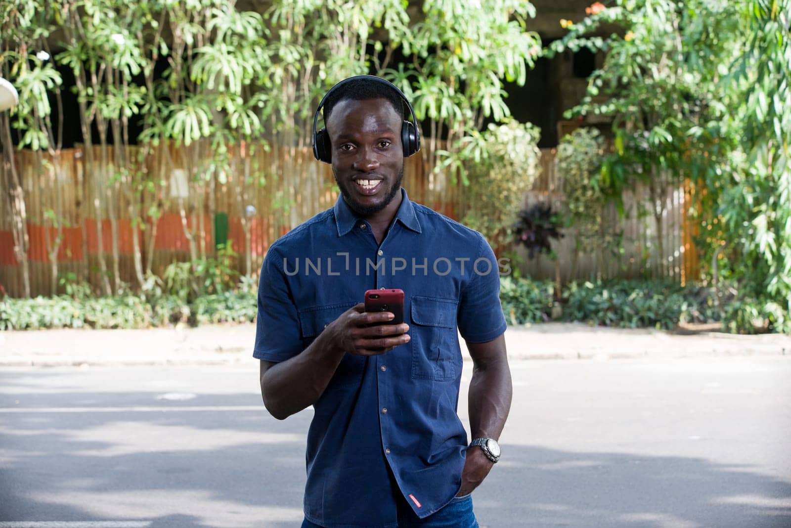 Man listens to music with headphones using a mobile phone outdoors.