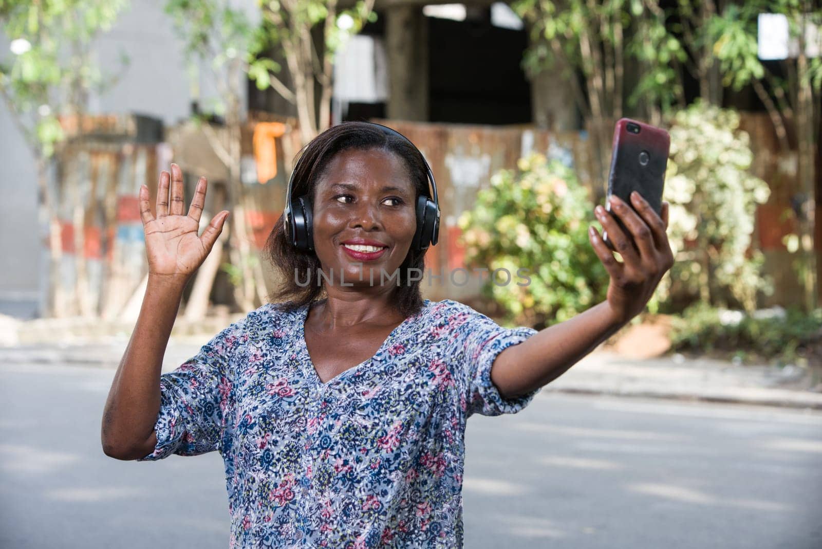 young woman standing outdoors looking at cell phone while smiling.portrait of a young woman with mobile phone.