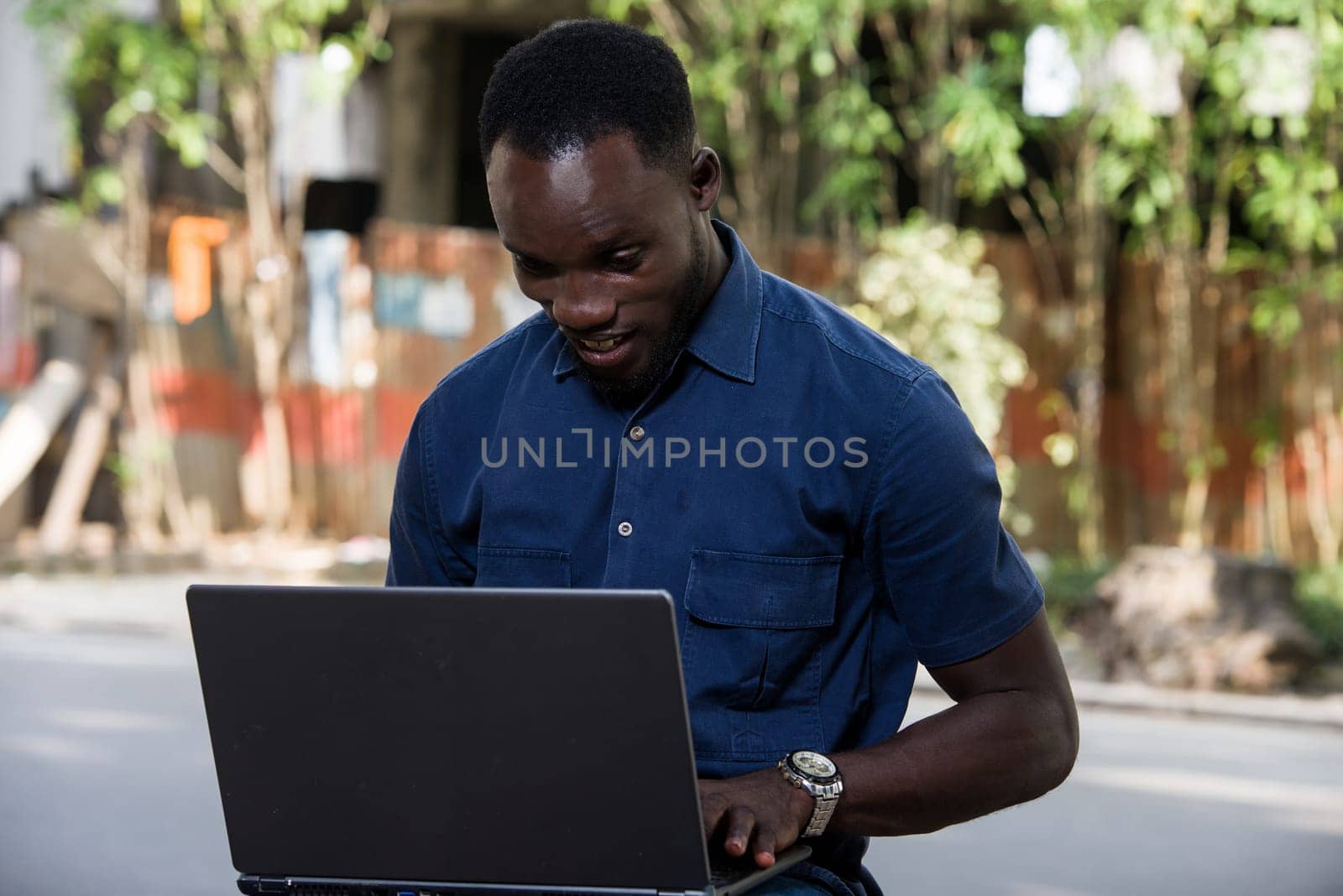 portrait of a smiling young man with laptop. by vystek