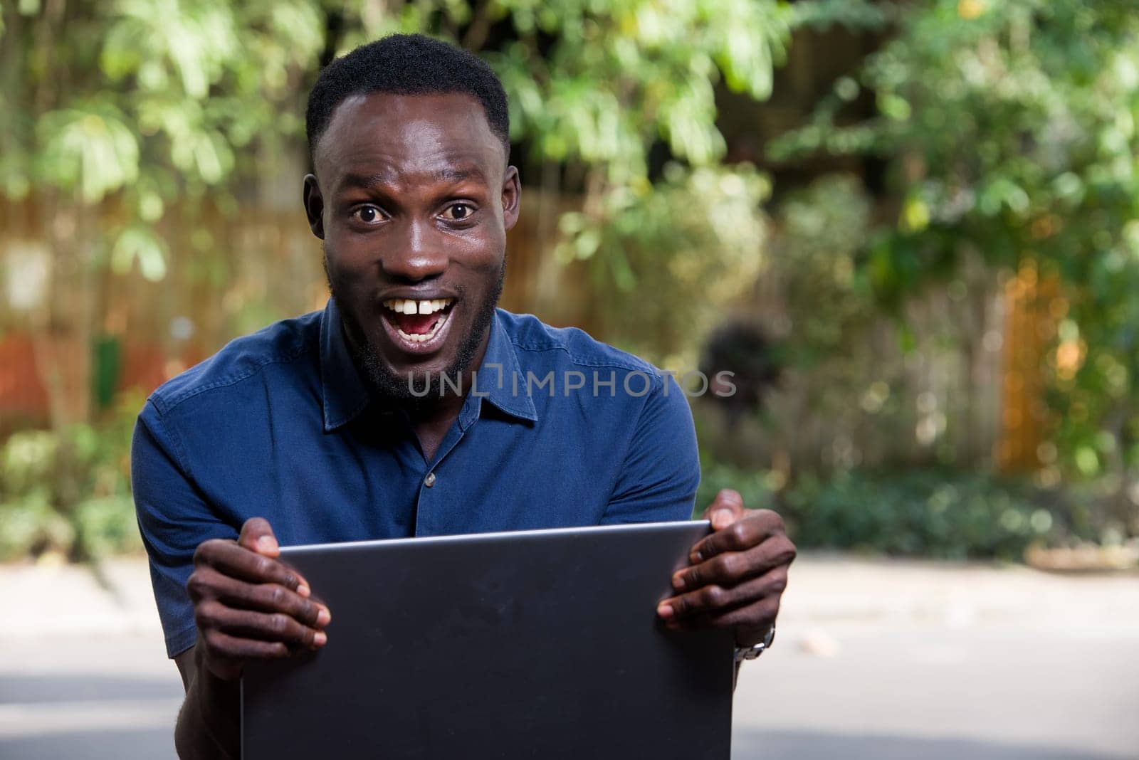 close up of a happy young man with laptop. by vystek
