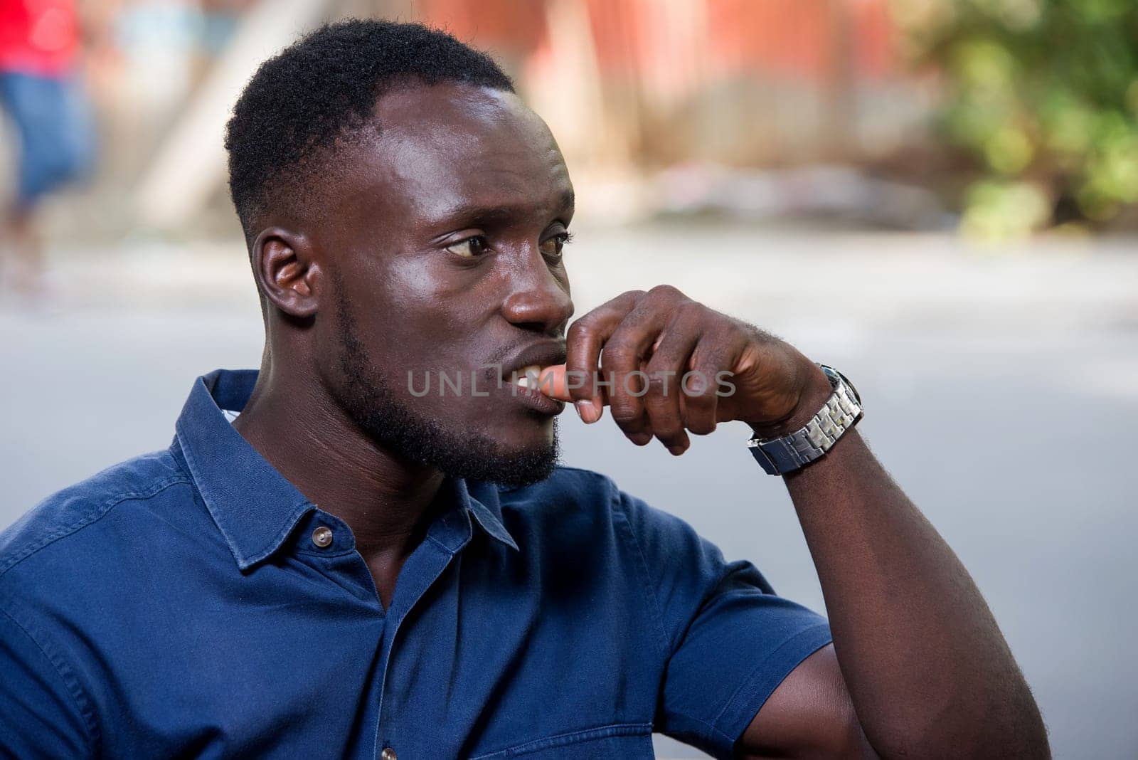 young man sitting outdoors thinking.